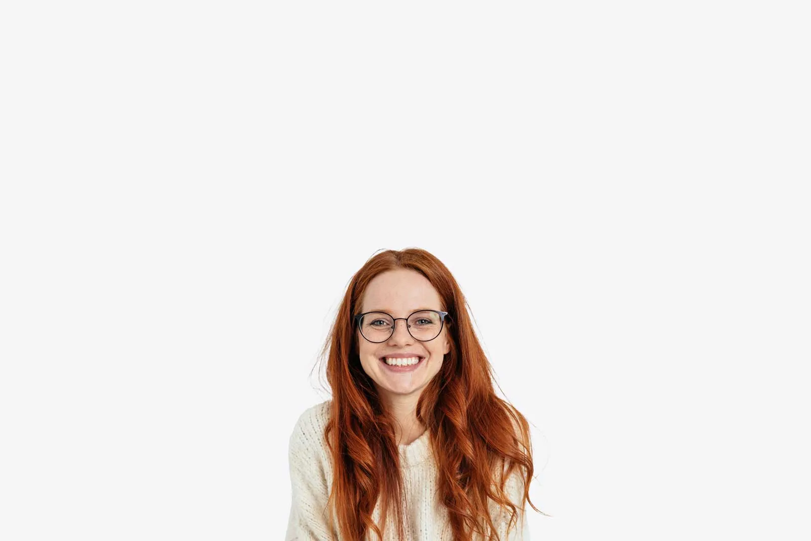A young woman with red hair and glasses smiling warmly